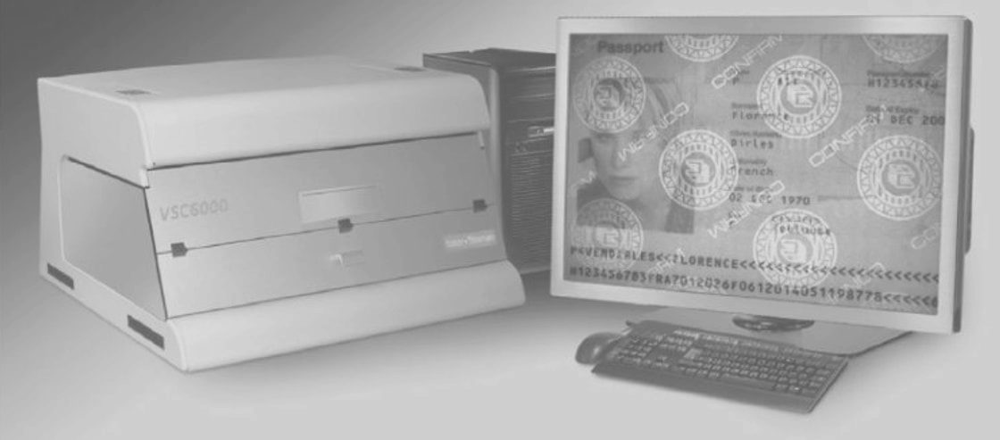 جهاز VSC 6000 لفحص الوثائق، وإلى جانبه شاشة تعرض جواز سفر تحت الفحص
